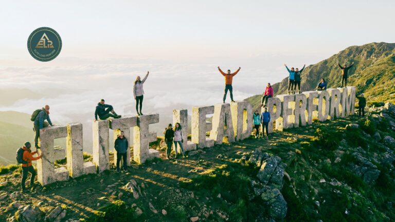 Group of people standing on a mountain ridge with the words “Elite Lead Perform,” symbolizing personal growth through clarity, structure, and conscious action.